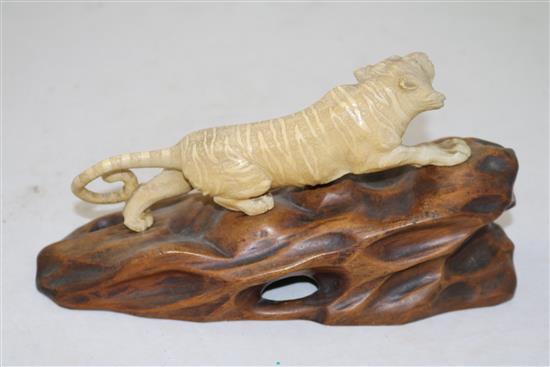 A Japanese ivory figure of a prowling tiger, Meiji period, length 26cm incl. carved wood stand